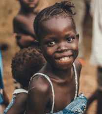 A smiling child supported by IRAID