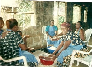 Group of women processing cassava for garri production.