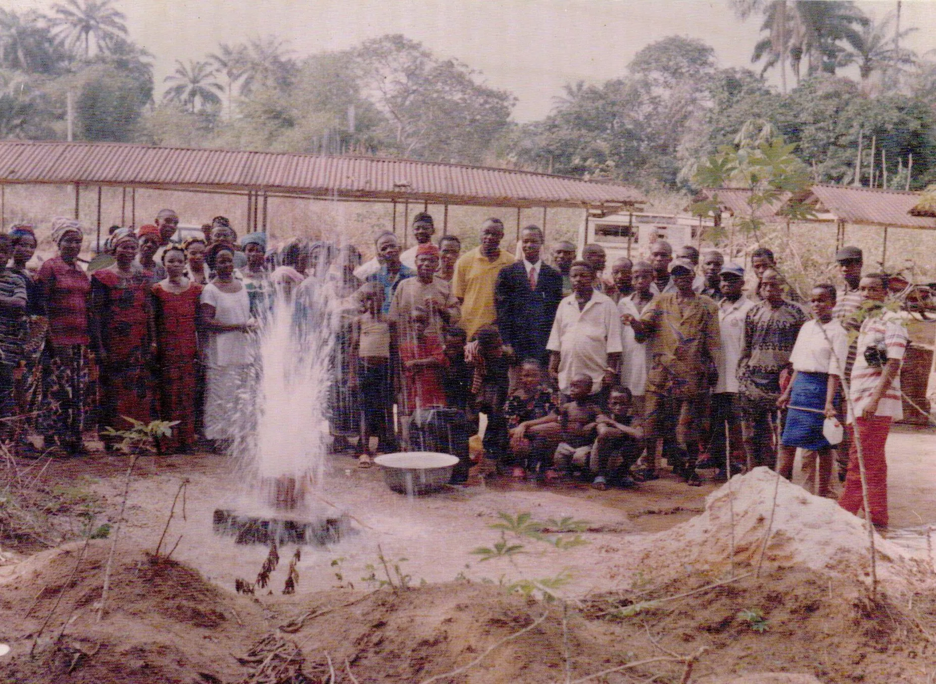Community members gathered around a flowing water point.